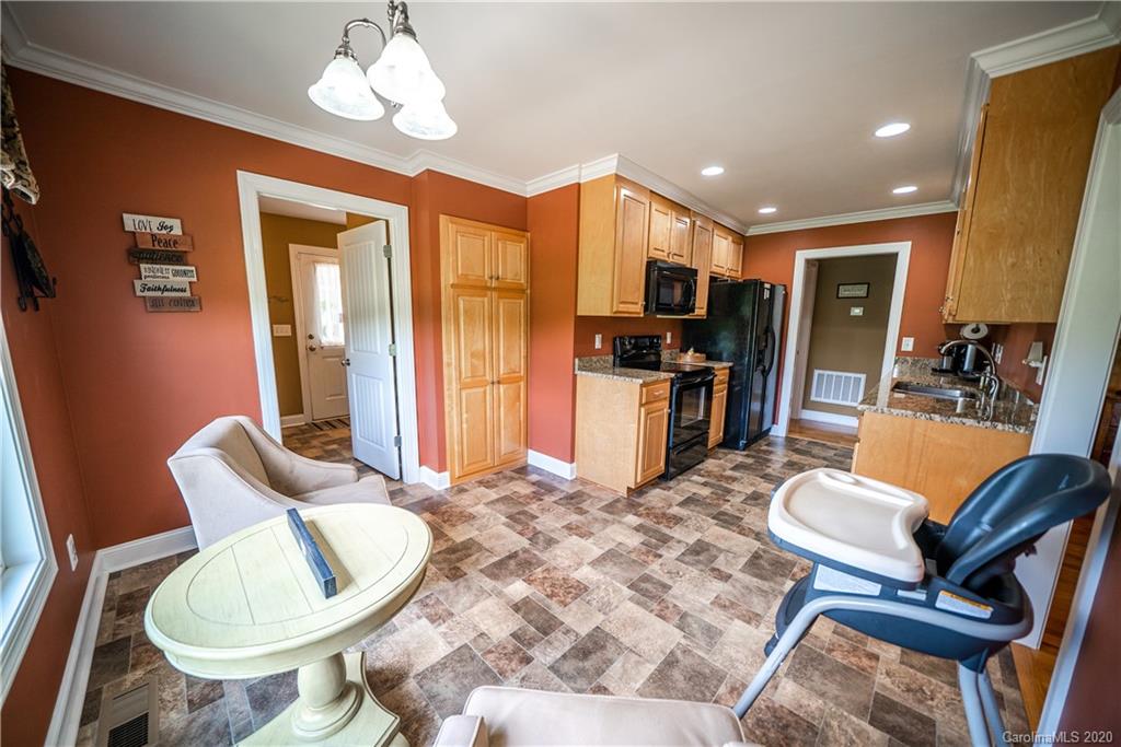 24376 Endy Road Albemarle, NC 28001 - Photo 15 of 27 a living room with furniture a flat screen tv and kitchen view