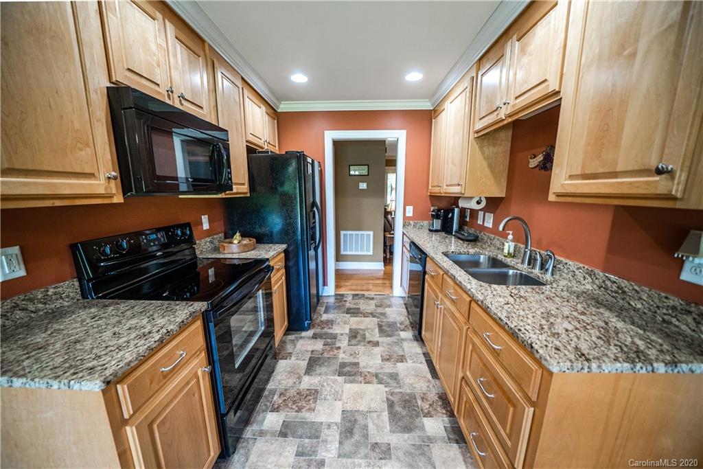 24376 Endy Road Albemarle, NC 28001 - Photo 16 of 27 a large kitchen with stainless steel appliances granite countertop a stove a sink and a microwave
