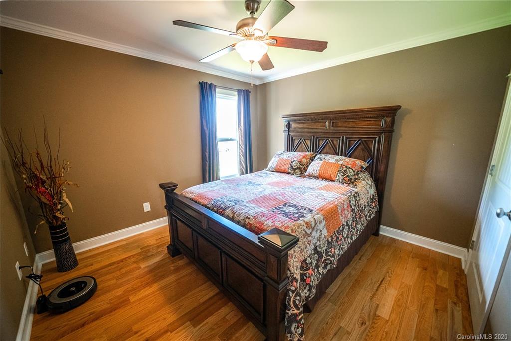 24376 Endy Road Albemarle, NC 28001 - Photo 23 of 27 a bedroom with a bed and a chandelier