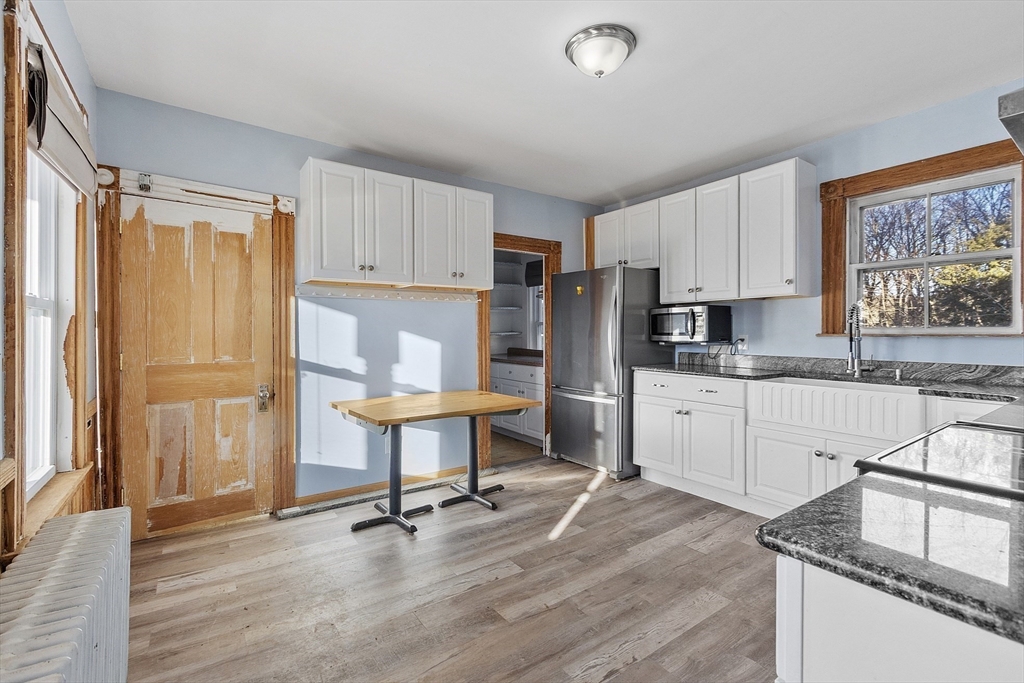 39 Terrace Street Orange, MA 01364 - Photo 5 of 40 a kitchen with granite countertop a refrigerator a stove a sink dishwasher and white cabinets with wooden floor