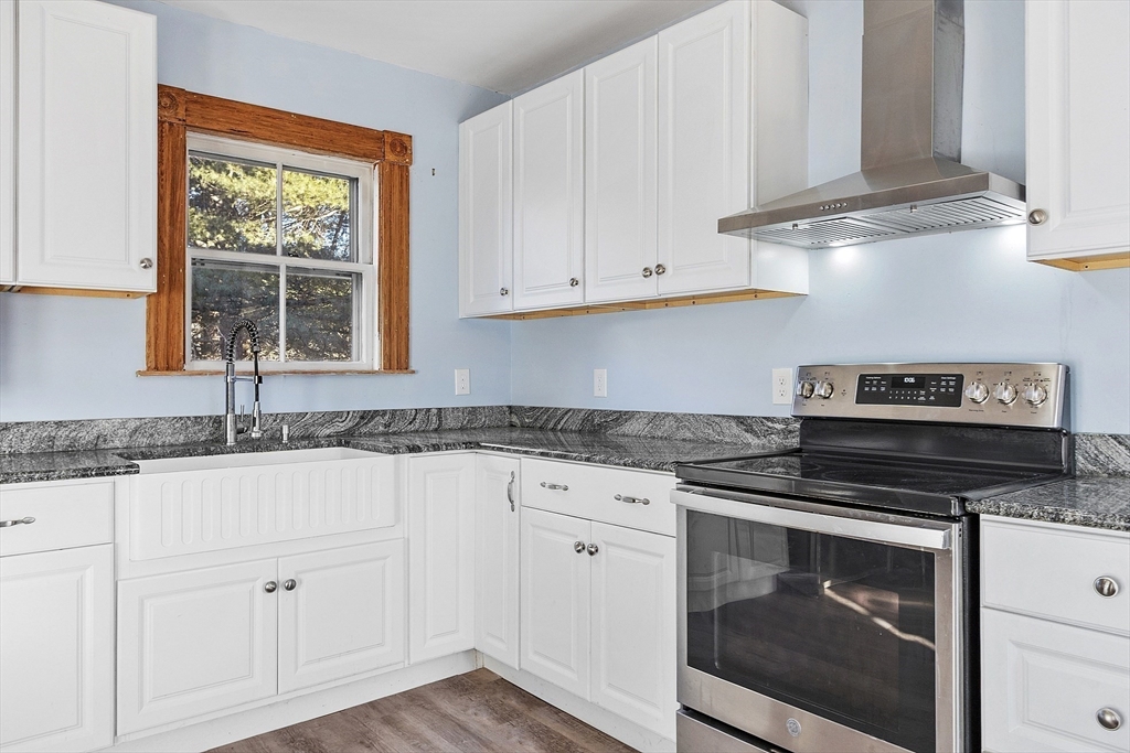39 Terrace Street Orange, MA 01364 - Photo 8 of 40 a kitchen with granite countertop white cabinets and a stove a sink with dishwasher