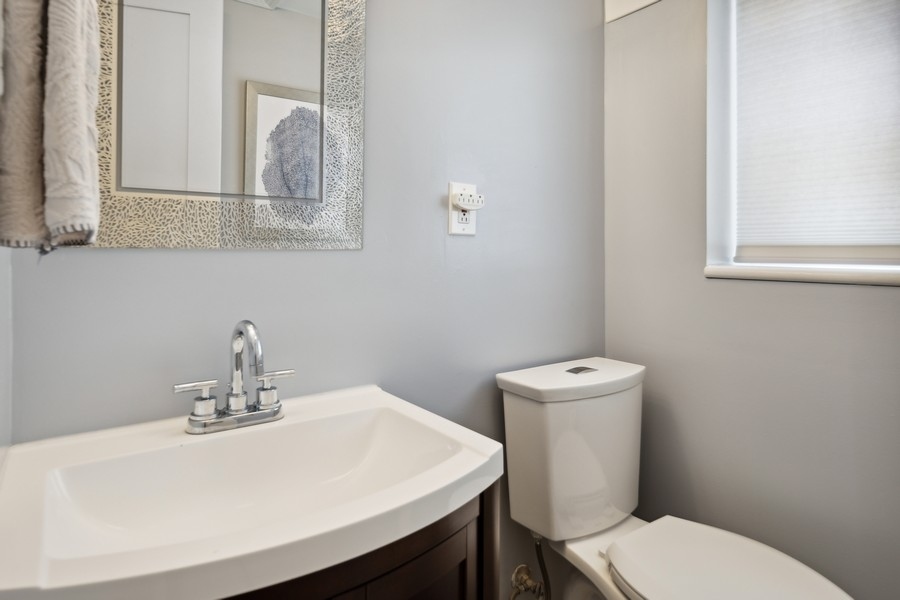 708 Long Road Glenview, IL 60025 - Photo 10 of 23 a bathroom with a sink a toilet and mirror
