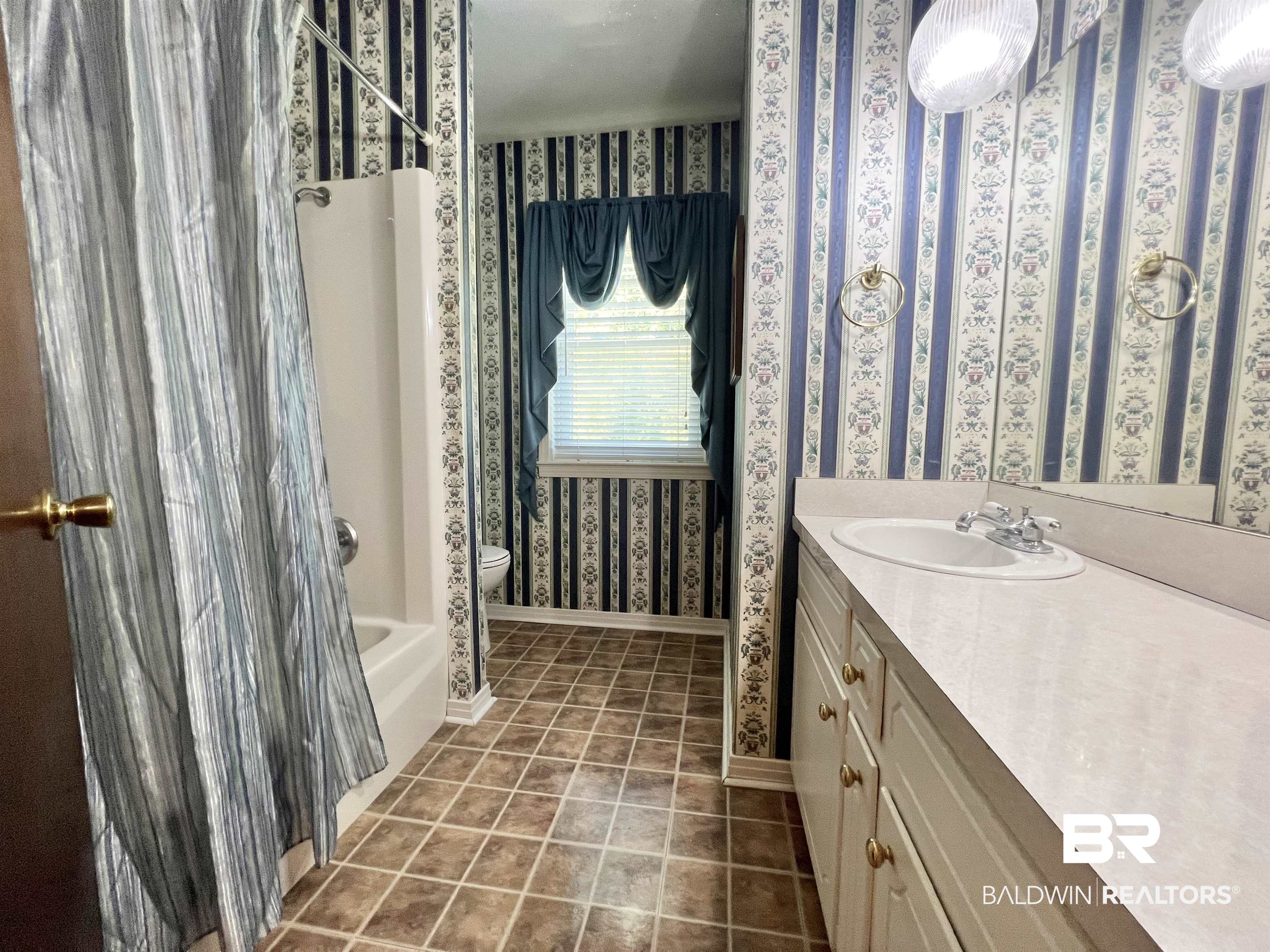 2691 Appleton Road Brewton, AL 36426 - Photo 42 of 60 Full bath featuring vanity, shower / washtub combination, wallpapered walls, and dark tile patterned floors