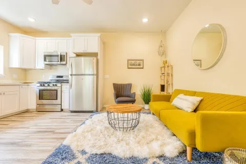 a bedroom with a bed and a view of living room