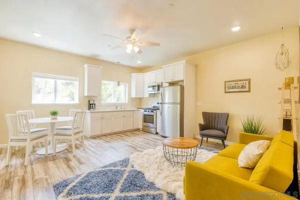 a living room with furniture and kitchen view