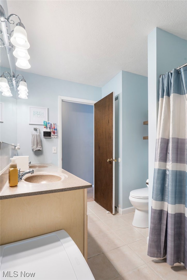 801 Netherwood Avenue Northwest Canton, OH 44708 - Photo 16 of 44 Bathroom featuring dual vanity, a textured ceiling, brand new toilet, and tile flooring