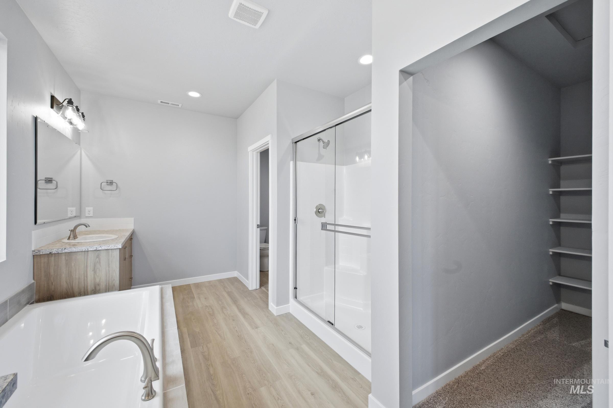 13672 Redway Court Caldwell, ID 83607 - Photo 31 of 34 Bathroom featuring vanity, a garden tub, light wood finished floors, a stall shower, and recessed lighting