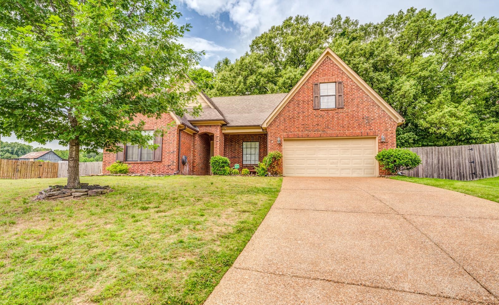 4671 Hampton Ridge Lane Bartlett, TN 38002 - Photo 2 of 40 Brick exterior with a detached garage, featuring a gabled roofline and a mature tree in the front yard