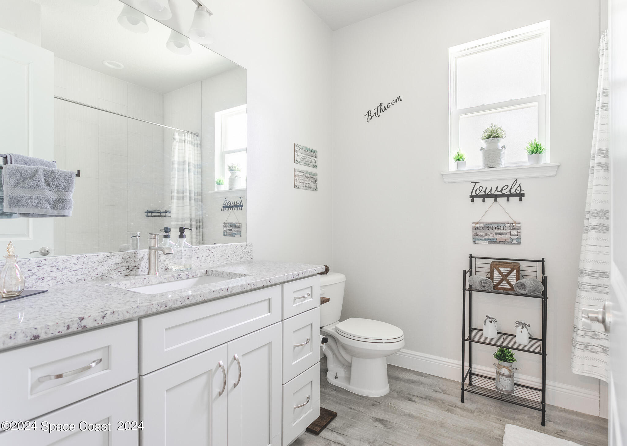 865 Hawks Ridge Court Northeast Palm Bay, FL 32905 - Photo 21 of 47 a spacious bathroom with a granite countertop sink a toilet and a mirror