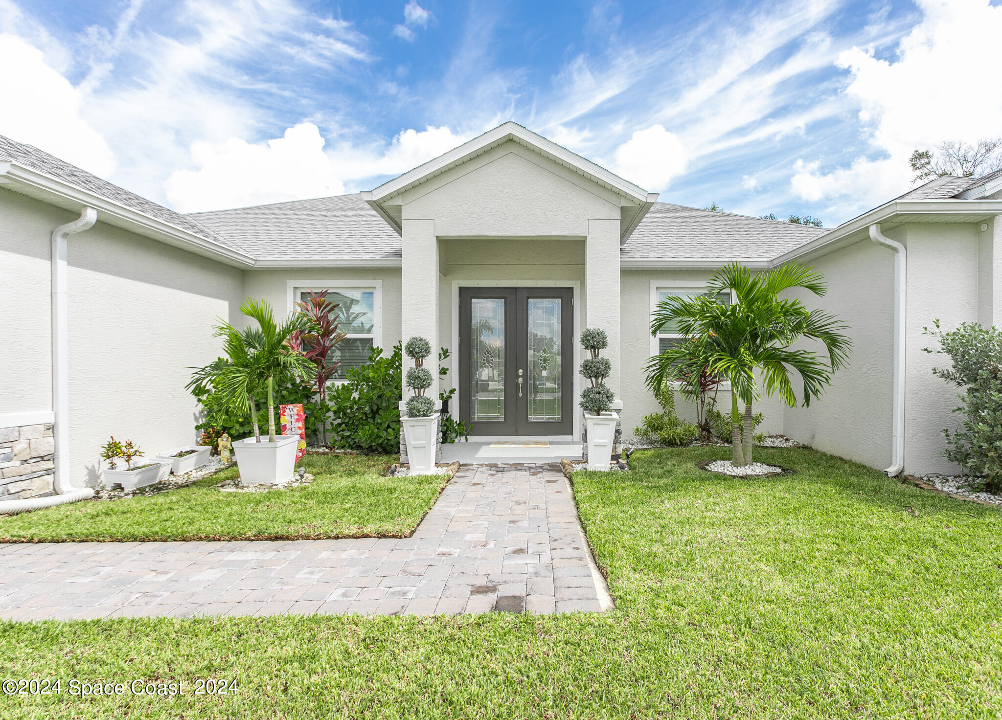 865 Hawks Ridge Court Northeast Palm Bay, FL 32905 - Photo 29 of 47 a front view of a house with a yard and potted plants