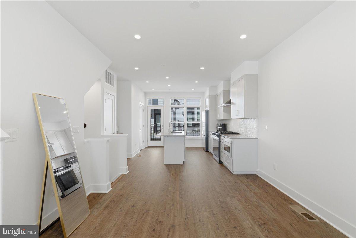 2018 Tysons Ridgeline Road Falls Church, VA 22043 - Photo 5 of 35 a view of a kitchen with refrigerator microwave and wooden floor