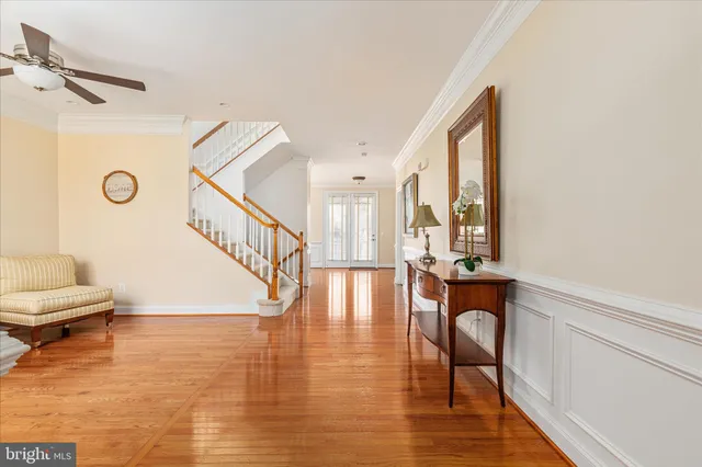 a living room with wooden floor and a ceiling fan