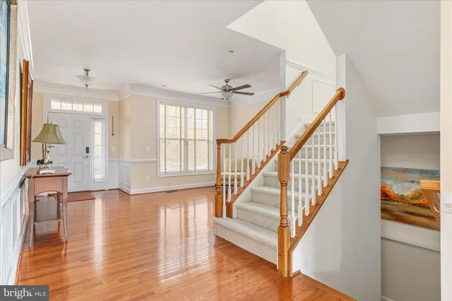 a kitchen with stainless steel appliances granite countertop a refrigerator a sink dishwasher and a stove with wooden floor