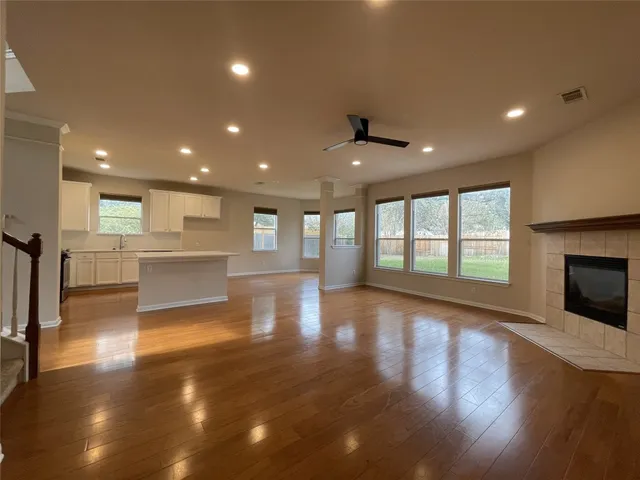 a view of a big room with wooden floor and a kitchen