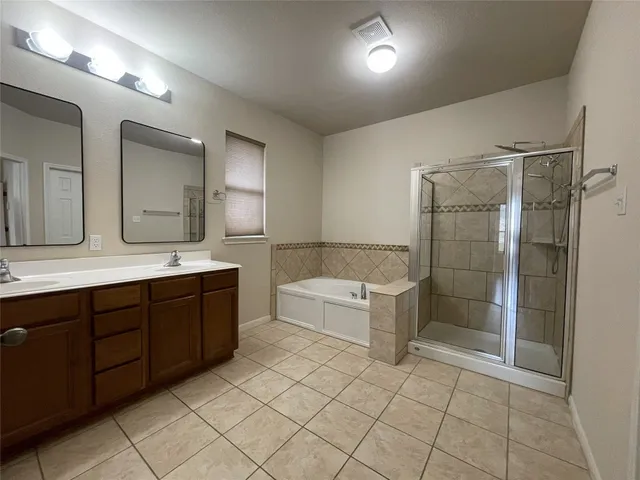 a spacious bathroom with a double vanity sink mirror and a bathtub