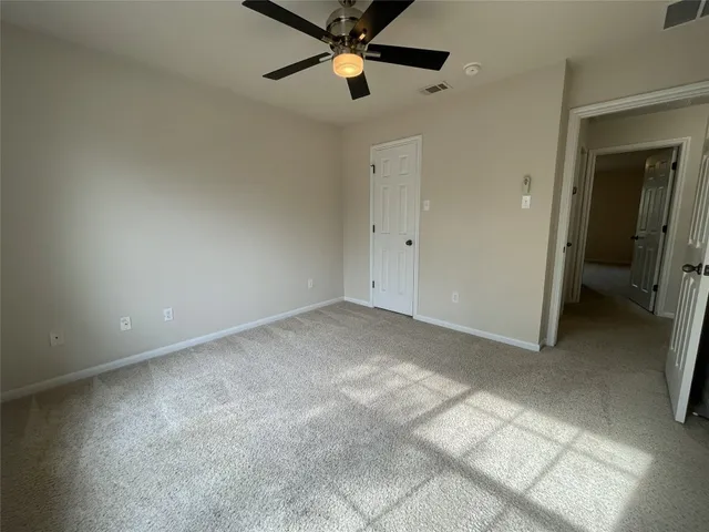 an empty room with closet and a chandelier fan