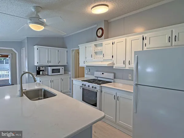 a kitchen with cabinets a sink a counter space and stainless steel appliances
