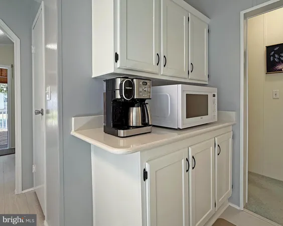 a kitchen with white cabinets and a refrigerator