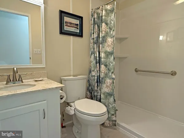 a bathroom with a granite countertop toilet sink and shower
