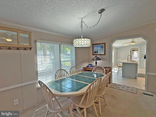 a dining room with furniture a chandelier and window