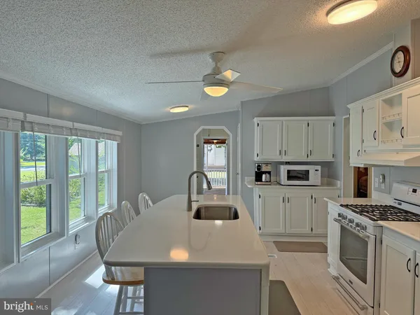 a kitchen with kitchen island white cabinets and refrigerator