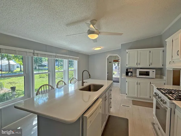 a kitchen that has a sink a stove and cabinets
