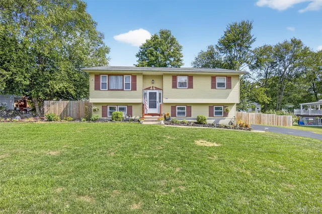 a view of house with a yard