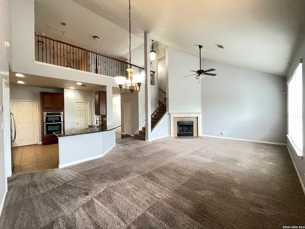 a view of an empty room and kitchen view