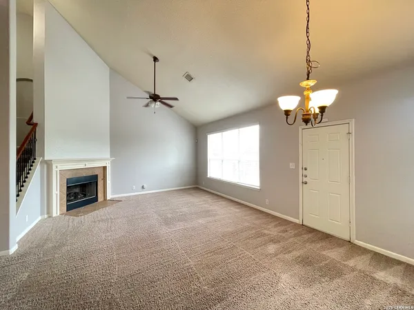 a view of an empty room with a fireplace and a window