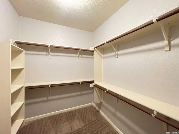 a view of walk in closet with empty racks
