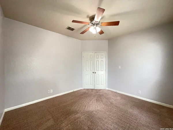 an empty room with windows and fan