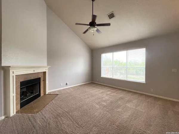 a view of empty room with fan and windows