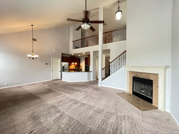 an empty room with windows and fireplace