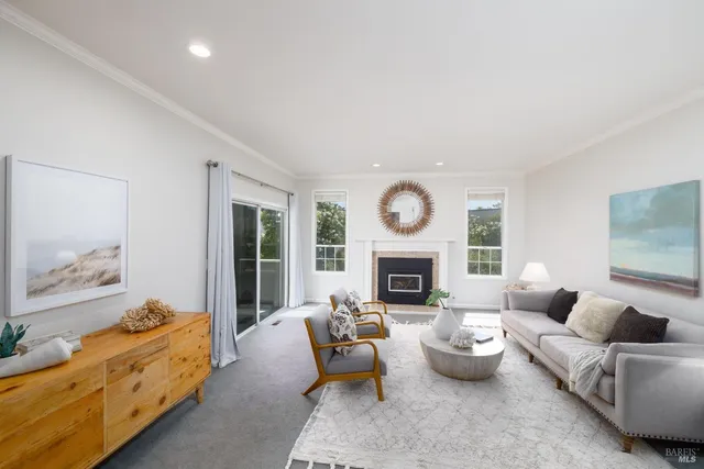 a living room with furniture fireplace and a large window