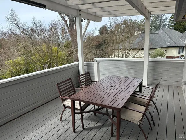 a view of deck with table and chairs under an umbrella