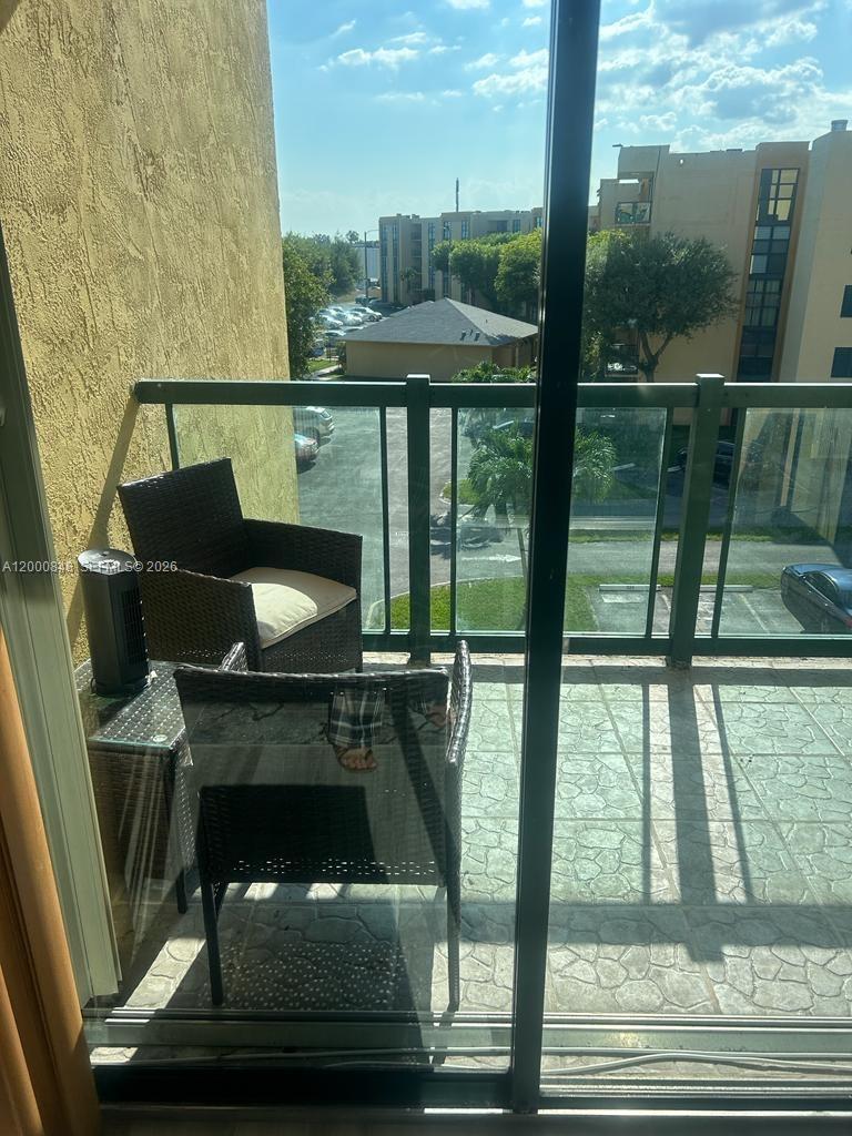 11790 Southwest 18th Street, Unit 4053 Miami, FL 33175 - Photo 17 of 17 a living room with a fireplace and a floor to ceiling window
