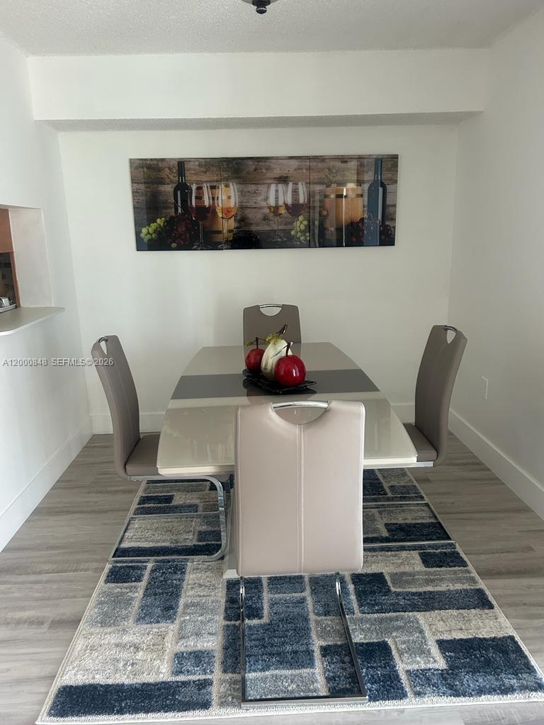 11790 Southwest 18th Street, Unit 4053 Miami, FL 33175 - Photo 4 of 17 a table chair sitting in a kitchen and a white wooden cabinets