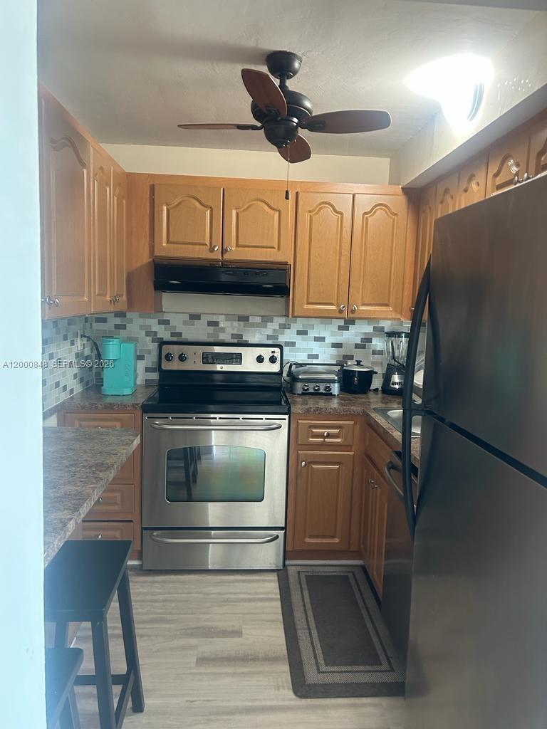 11790 Southwest 18th Street, Unit 4053 Miami, FL 33175 - Photo 7 of 17 a kitchen with granite countertop a refrigerator stove and sink