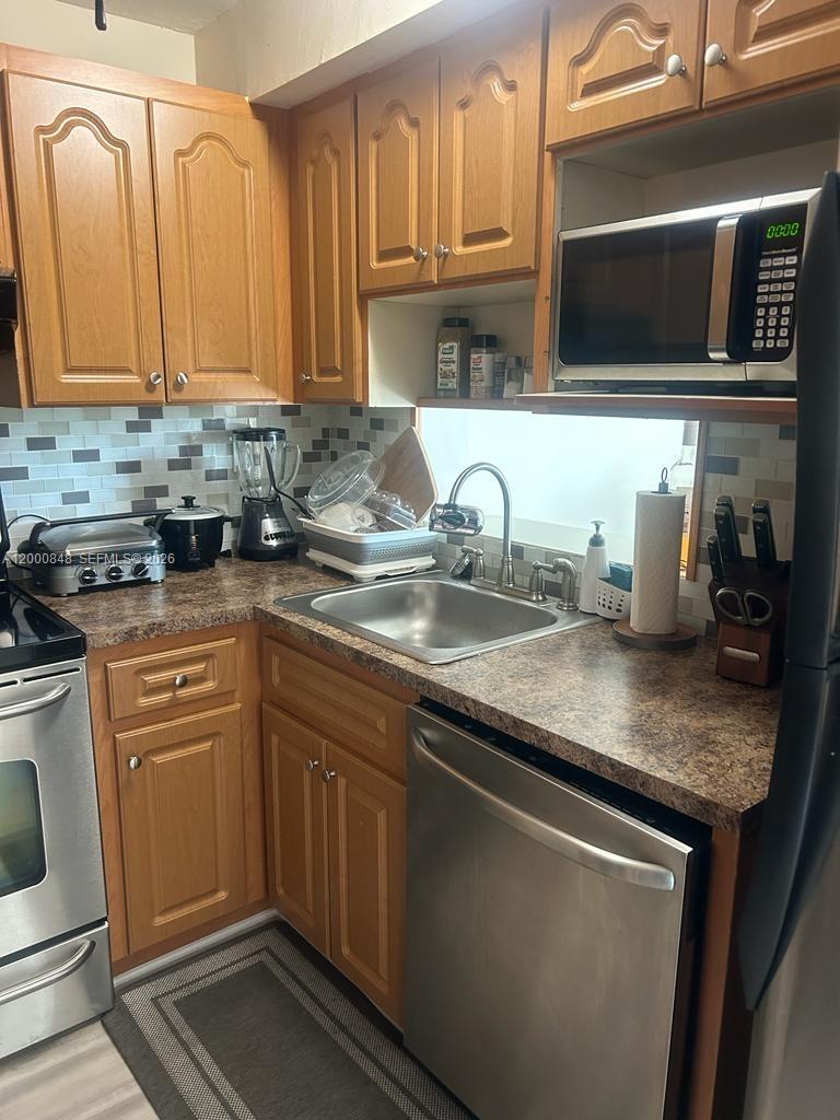 11790 Southwest 18th Street, Unit 4053 Miami, FL 33175 - Photo 9 of 17 a kitchen with granite countertop a sink stainless steel appliances and cabinets