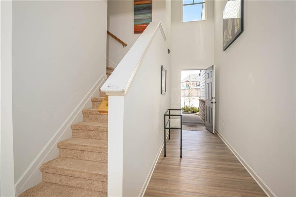 5760 Flint Lane Cumming, GA 30028 - Photo 16 of 39 a view of a hallway with wooden floor and staircase