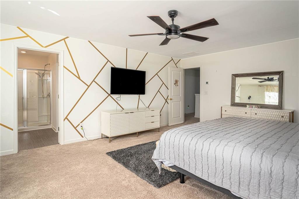 5760 Flint Lane Cumming, GA 30028 - Photo 20 of 39 a bedroom with a bed a flat screen tv and a ceiling fan