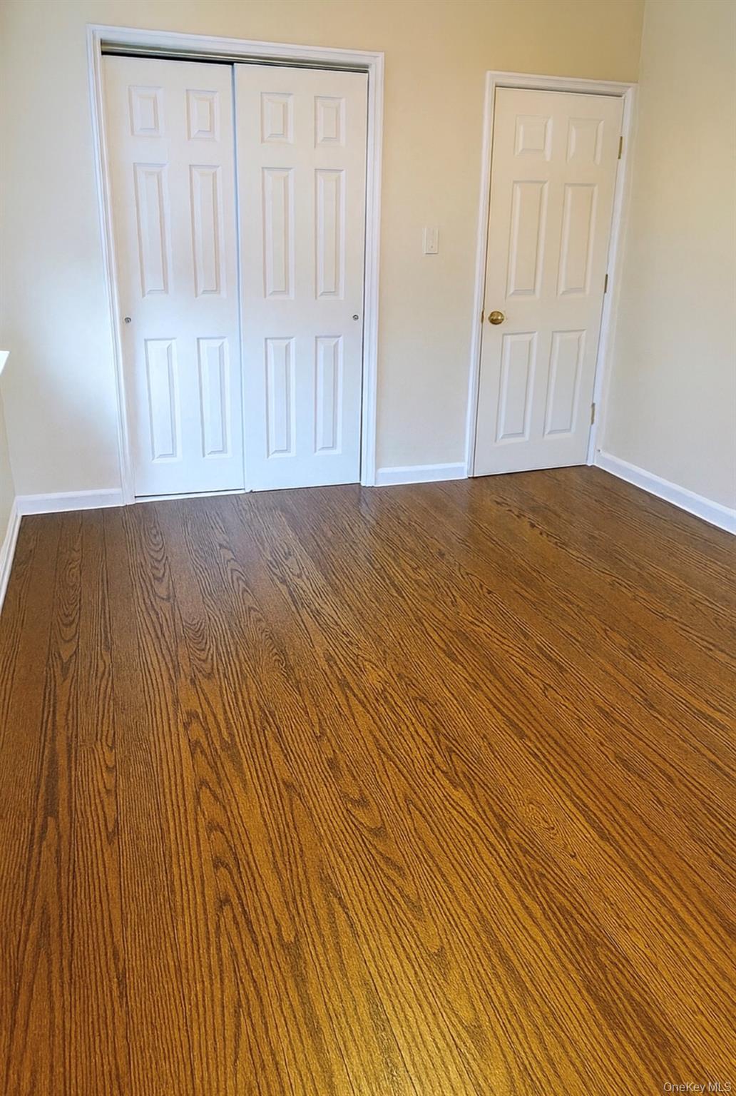 220 Pelham Road, Unit 6G New Rochelle, NY 10805 - Photo 8 of 24 an empty room with wooden floor and windows