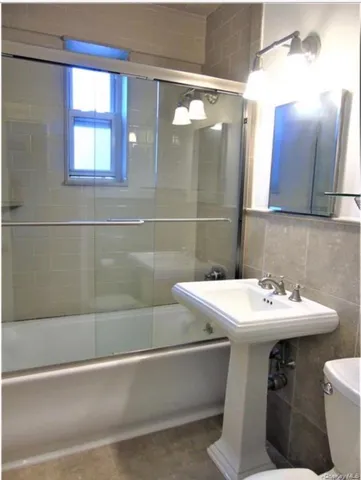 a bathroom with a sink a toilet and mirror