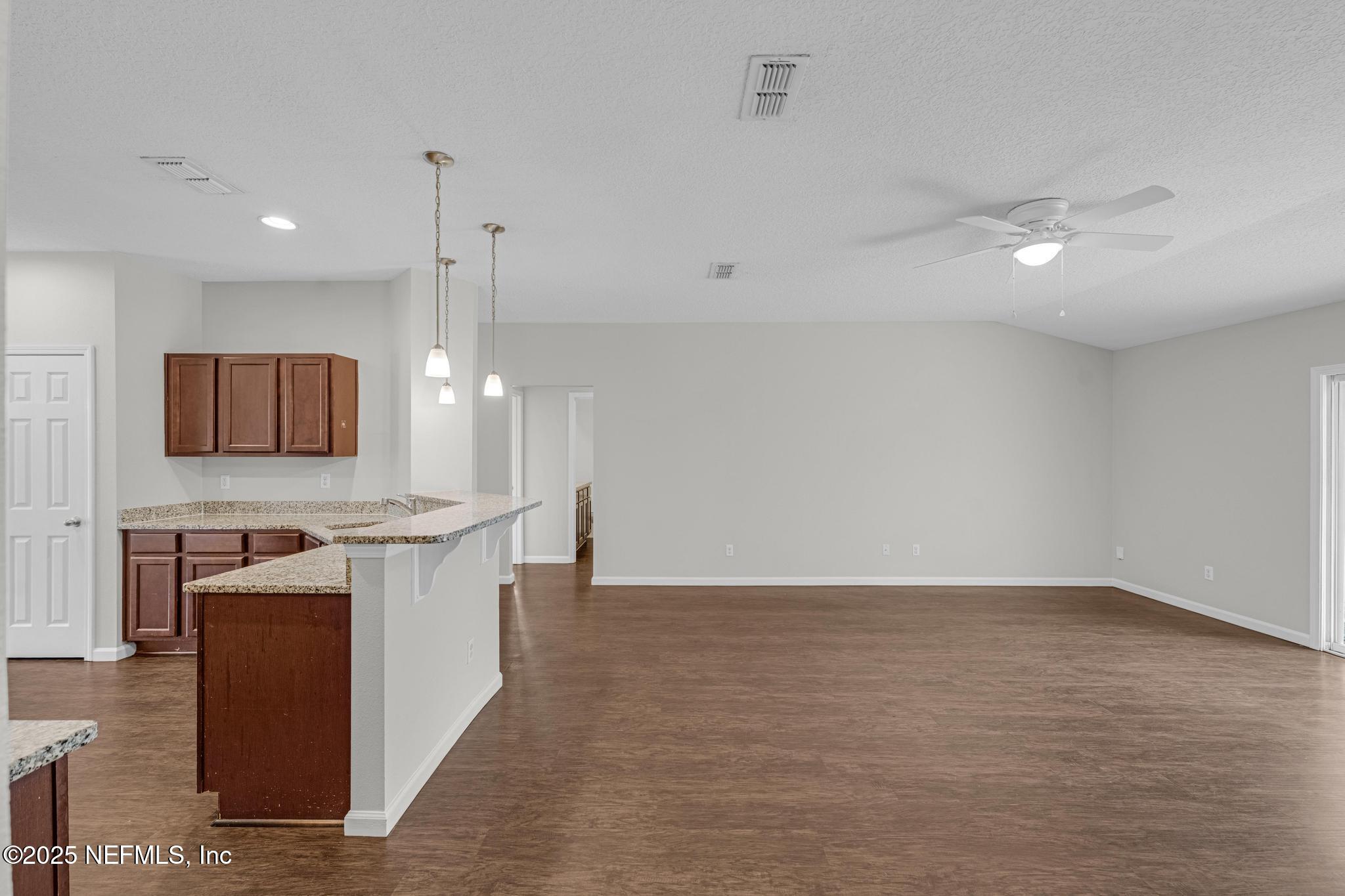 5120 Dugdale Road Jacksonville, FL 32210 - Photo 19 of 32 a view of a kitchen with kitchen island a sink wooden floor and a counter top space