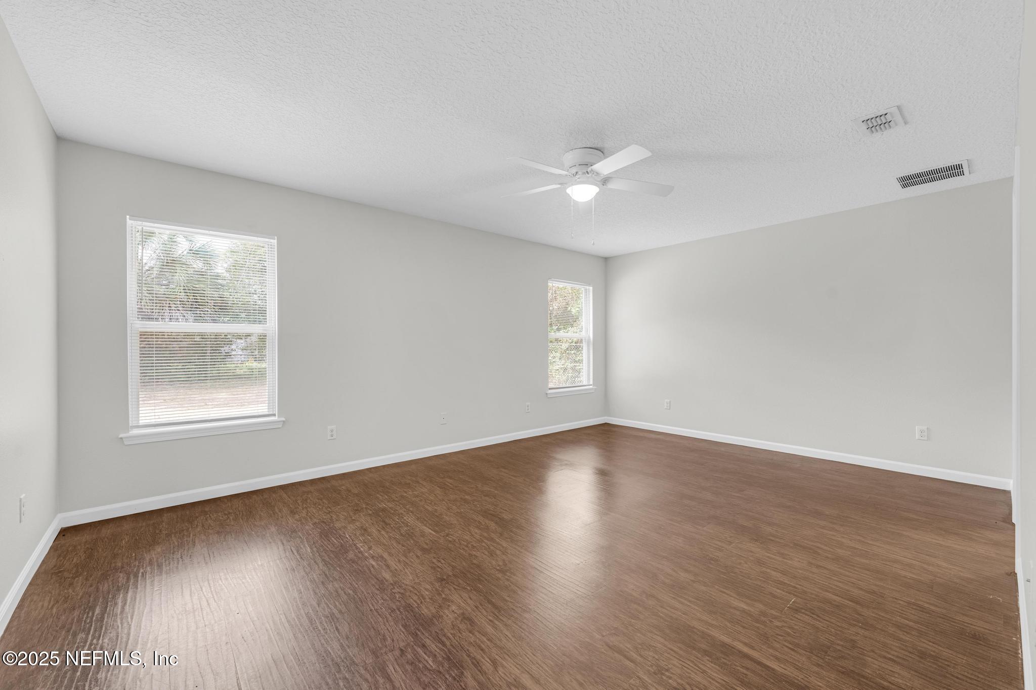5120 Dugdale Road Jacksonville, FL 32210 - Photo 21 of 32 a view of an empty room with wooden floor and a window