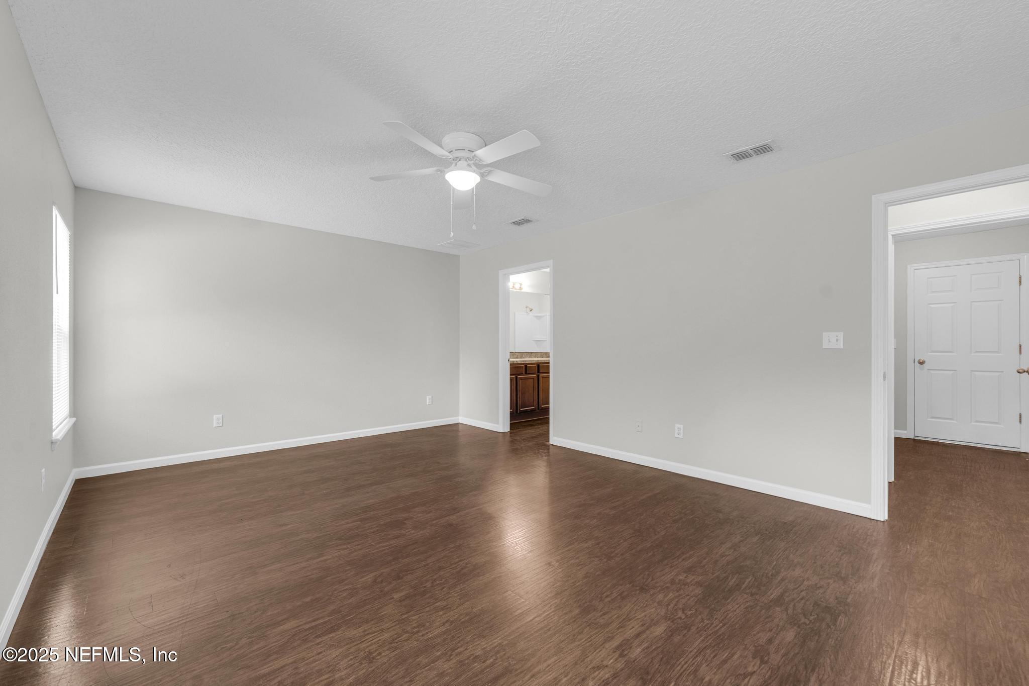 5120 Dugdale Road Jacksonville, FL 32210 - Photo 22 of 32 a view of an empty room with wooden floor and a ceiling fan