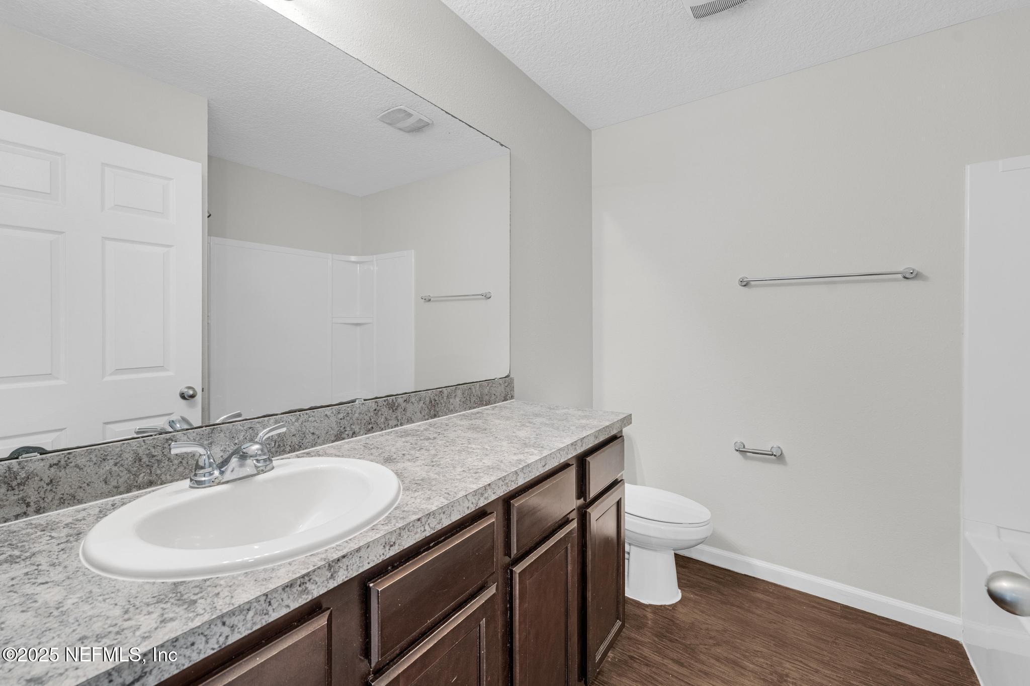 5120 Dugdale Road Jacksonville, FL 32210 - Photo 26 of 32 a bathroom with a granite countertop sink a toilet and a mirror