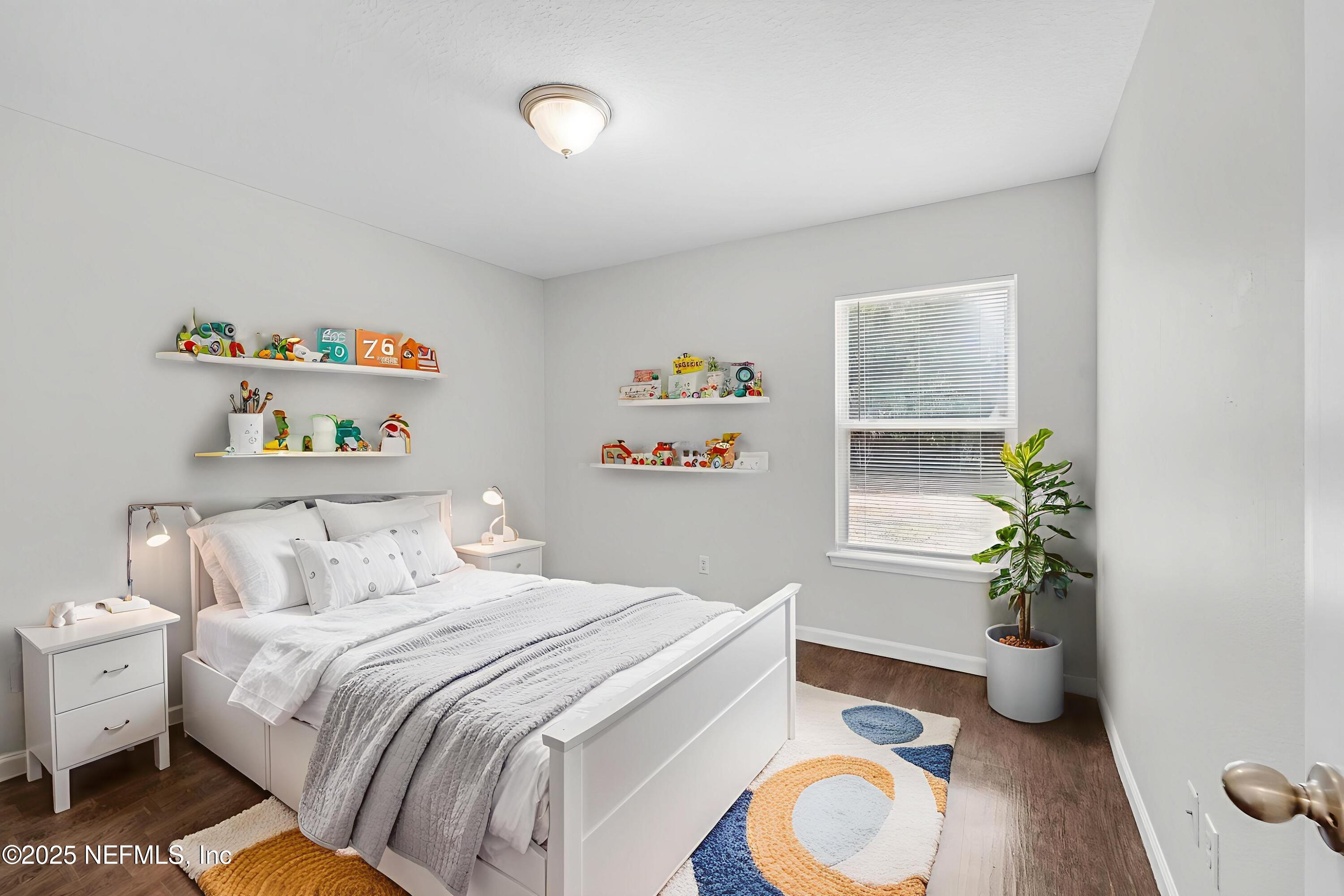 5120 Dugdale Road Jacksonville, FL 32210 - Photo 27 of 32 a bedroom with a bed and a potted plant