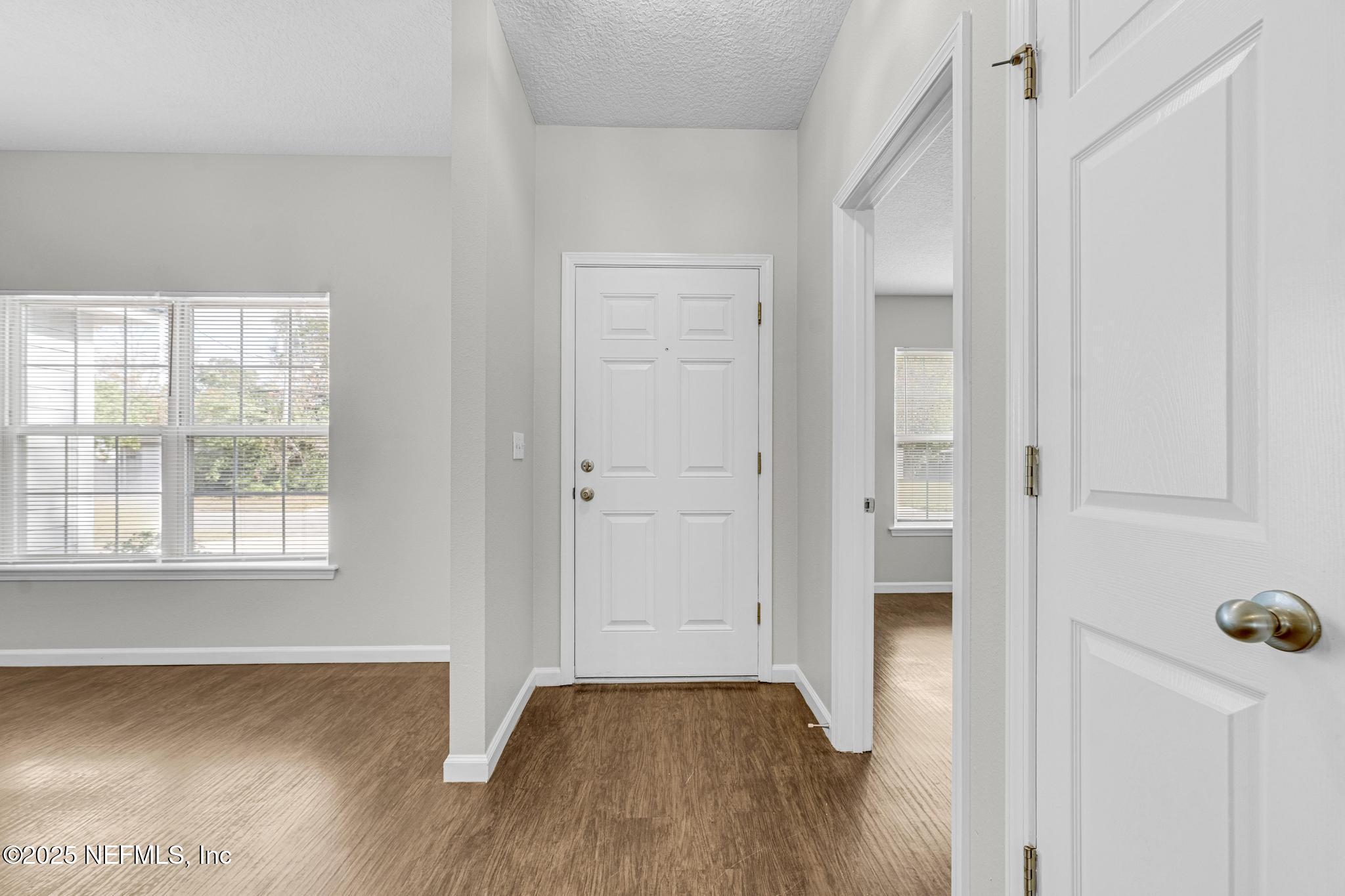 5120 Dugdale Road Jacksonville, FL 32210 - Photo 4 of 32 an empty room with wooden floor and windows