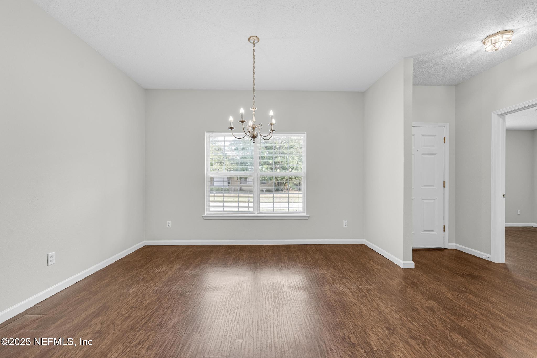 5120 Dugdale Road Jacksonville, FL 32210 - Photo 9 of 32 a view of an empty room with wooden floor and a window